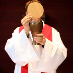 a man in a priest's robes holding a chalice