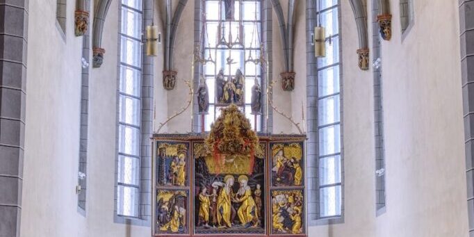The inside of a church with pews and stained glass windows